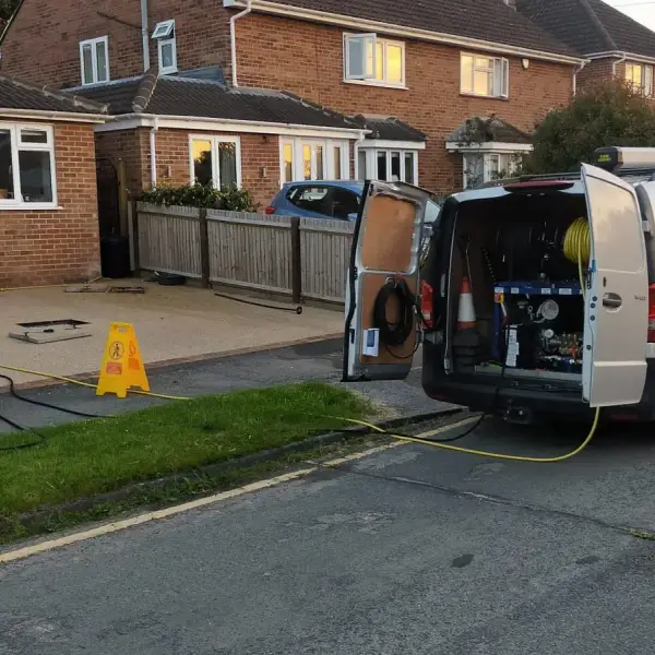 Vision Plumbing van on a driveway with the jetting hose run to a blocked drain