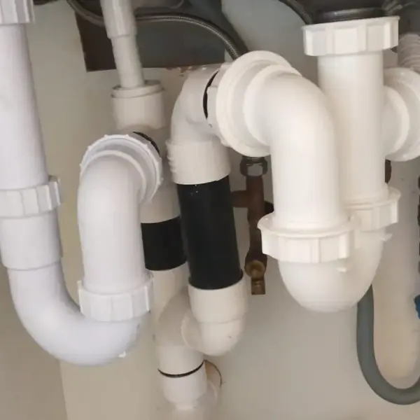 New kitchen waste traps and pipework under a double sink