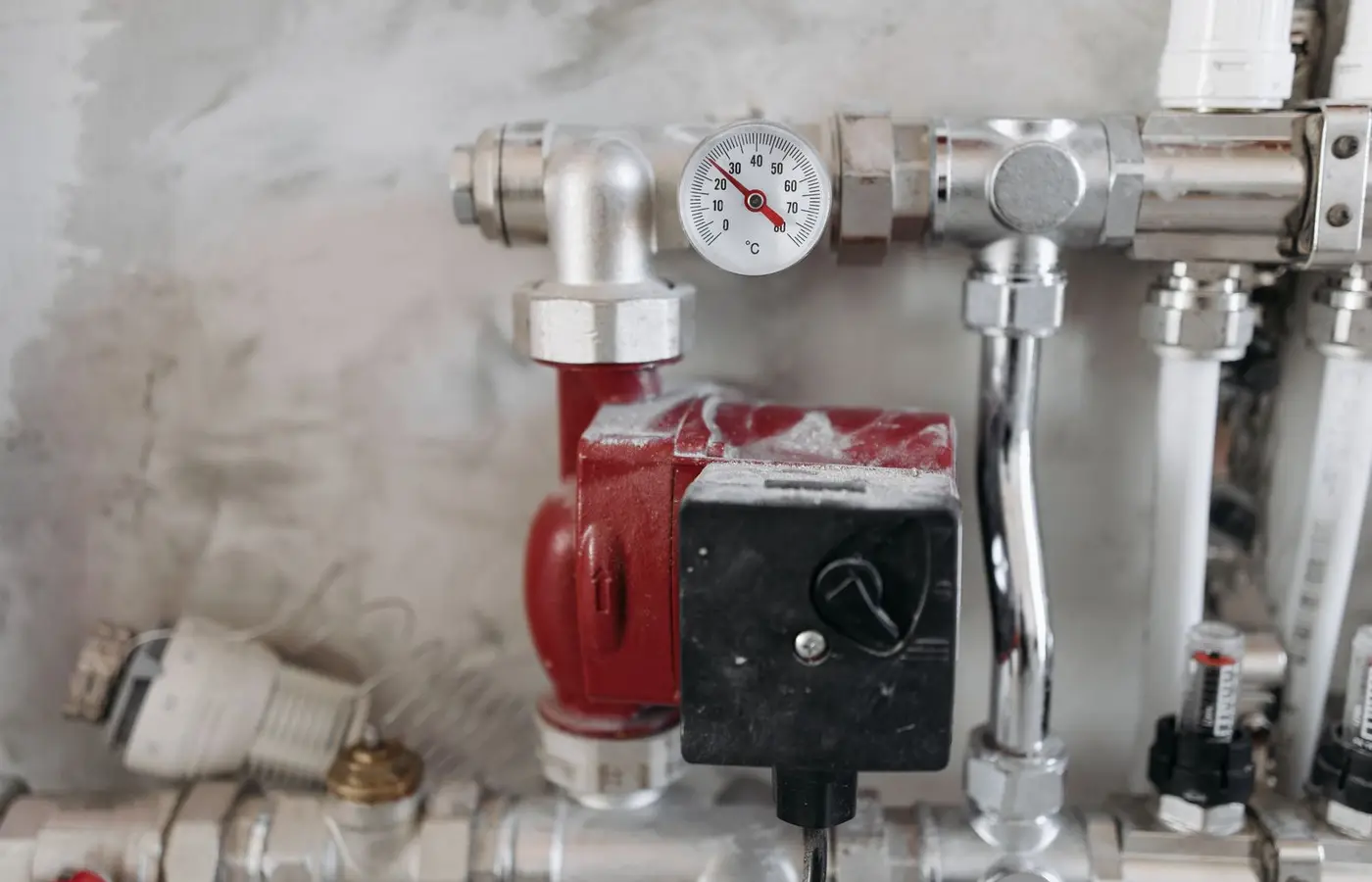 Close-up view of an industrial plumbing system featuring a pressure gauge and steel pipes.