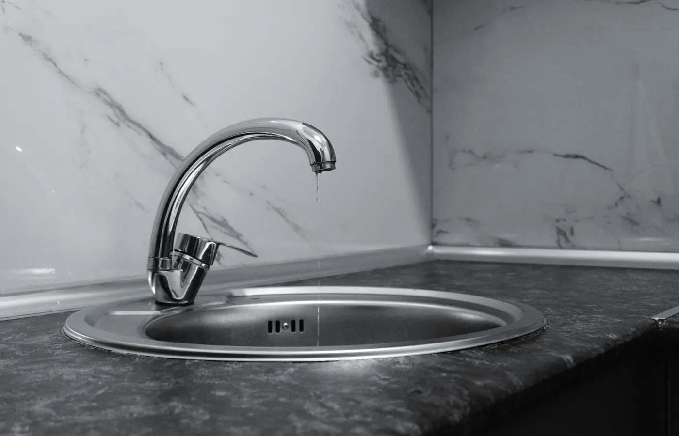 A clean and modern kitchen sink with a chrome faucet, highlighting minimalist design and water conservation.